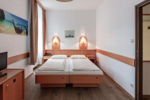 ein Krankenhauszimmer mit 2 Betten und einem TV in der Unterkunft Hotel Admiral in Wien