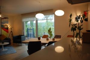 sala de estar con mesa y ventana grande en Gîte'appart "des cîmes et jardin", en Illkirch-Graffenstaden