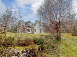 una casa en una colina con un árbol en un campo en 3 bed in Achnasheen CA120, en Inveralligin