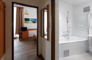 a bathroom with a bath tub and a sink at Hotel Admiral in Vienna