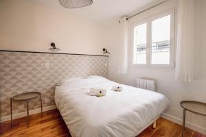 sypialnia z białym łóżkiem i 2 ręcznikami w obiekcie Lovely apartment for two-person w mieście Aubervilliers