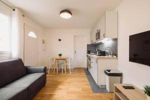 uma sala de estar com um sofá e uma cozinha em Lovely apartment for two-person em Aubervilliers