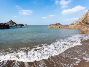 a beach with rocks in the water and the ocean at 2 Bed in Ilfracombe 66328 in Ilfracombe