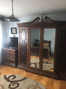 um quarto com um armário de madeira com um espelho em Vila Ana Ipatescu em Craiova