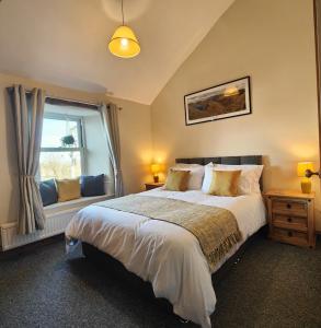 ein Schlafzimmer mit einem großen Bett und einem Fenster in der Unterkunft The Herdwick Inn in Penruddock