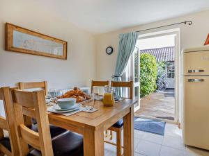 a kitchen with a wooden table with chairs and a dining room at 3 Bed in Heacham 65596 in Heacham