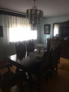 Vila Ana Ipatescu في كرايوفا: غرفة طعام مع طاولة وكراسي ونافذة