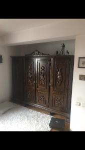 a large wooden cabinet in the corner of a room at Vila Ana Ipatescu in Craiova