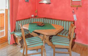 クライナルにあるNice Apartment In Kleinarl With 2 Bedrooms And Wifiの赤い壁の部屋(木製のテーブルと椅子付)