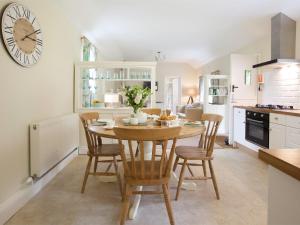a kitchen with a table and chairs and a clock on the wall at 2 Bed in Howden G0104 in Saltmarshe