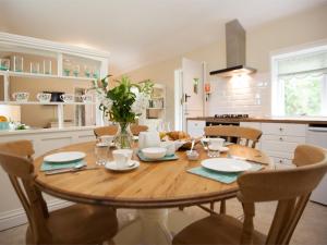 a kitchen with a wooden table with chairs and a dining room at 2 Bed in Howden G0104 in Saltmarshe
