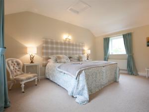 a bedroom with a bed and a chair and a window at 2 Bed in Howden G0104 in Saltmarshe