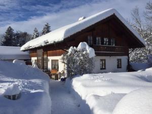 una casa cubierta de nieve delante en Haus Mona **** en Bad Heilbrunn
