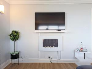 a living room with a tv above a fireplace at The Gables in Bognor Regis