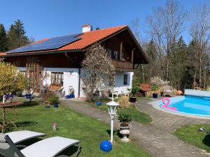 a house with a swimming pool in front of it at Haus Mona **** in Bad Heilbrunn