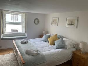 ein Schlafzimmer mit einem großen Bett mit Handtüchern darauf in der Unterkunft Drift Cottage - Fisherman's Cottage Brixham harbour in Brixham
