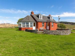 una casa roja con una pared de piedra en un campo en 2 bed in Kilfinan CA183, en Kilfinan