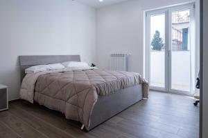 een slaapkamer met een groot bed en een groot raam bij ANSIRO Rooms Home Business in Scisciano