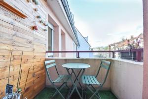 two chairs and a table on a balcony at Lumineux - Elixir - Parking privé in Strasbourg