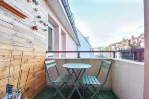 two chairs and a table on a balcony at Lumineux - Elixir - Parking privé in Strasbourg