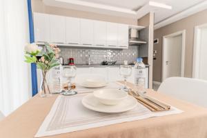 Olea Suites Gemlik في غِمليك: طاولة عليها صحون و كاسات و ورد