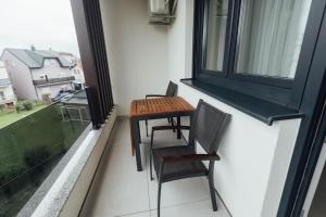 a table and chairs on a balcony with a window at Grgic Apartments - Lux APT2 - Free Parking in Zagreb