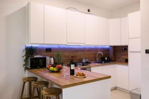 a kitchen with a counter with a bowl of fruit and wine glasses at Grgic Apartments - Lux APT2 - Free Parking in Zagreb