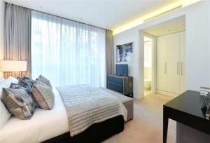 a bedroom with a bed with a desk and a window at PARK LANE LARGE LUXURY SLEEPS 6 in London