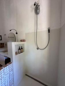 a bathroom with a shower in a white wall at Casa Chão in Prado