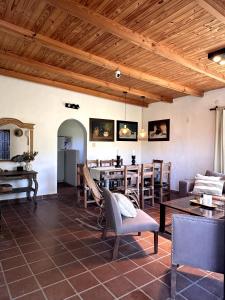 een woonkamer met houten plafonds en tafels en stoelen bij Casa Los Membrillos in Tafí del Valle