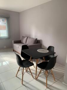 ein Wohnzimmer mit einem Tisch, Stühlen und einem Sofa in der Unterkunft Aconchego in Petrolina
