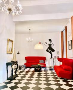 sala de estar con muebles de color rojo y suelo a cuadros en B&B Château de Fajac la Selve, en Pech-Luna