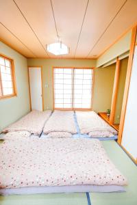 a large bed in a room with two windows at BBQ!最大14人!駅から5分&有馬温泉直達!長田 in Kobe