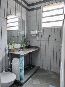 a bathroom with a sink and a toilet and a mirror at Casa Monjardim in Vitória