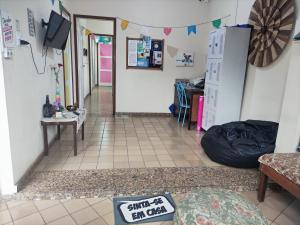 a room with a hallway with a table and a tv at Casa Monjardim in Vitória