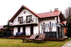 凯亚Casa Santha - hospitality & spa的前面有两把椅子的白色房子