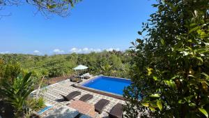 a swimming pool in the middle of a garden at La village hills view in Nusa Penida