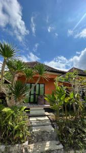 une maison avec des palmiers devant elle dans l'établissement La village hills view, à Nusa Penida