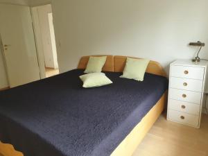 um quarto com uma cama com duas almofadas e uma cómoda em Ferienhaus in Wilhelmshöhe em Kassel