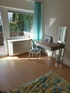 Zimmer mit einem Schreibtisch, einem Stuhl und einem Fenster in der Unterkunft Ferienhaus in Wilhelmshöhe in Kassel