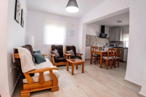 a living room with wooden chairs and a table at Casa Petra in Vejer de la Frontera