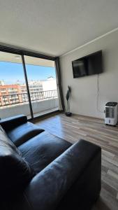 - un salon avec un canapé et une grande fenêtre dans l'établissement Depto nuevo en republica cercano al movistar arena, à Santiago