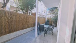 eine Terrasse mit einem Tisch, Stühlen und einem Zaun in der Unterkunft STAY Elysian House in Limassol