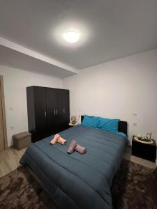 um quarto com uma grande cama azul com duas toalhas em Bakopoulos Resort Ένα όμορφο και ήσυχο διαμέρισμα στα Τρίκαλα em Trikala
