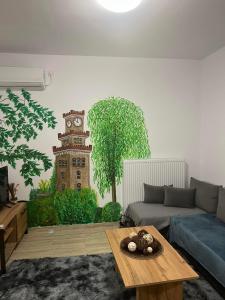 uma sala de estar com um sofá e uma torre de relógio pintada na parede em Bakopoulos Resort Ένα όμορφο και ήσυχο διαμέρισμα στα Τρίκαλα em Trikala