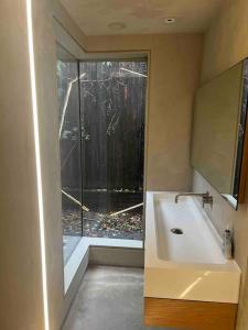 ein Bad mit einem Waschbecken und einem Fenster in der Unterkunft Luxury Guest House in Woodstock