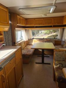 a kitchen and living room with a couch and a table at Geweldige caravan op een off-grid locatie in Santo Tomé