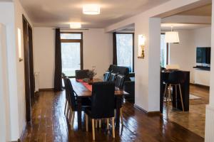 a dining room and living room with a table and chairs at Villa Santha in Cheia