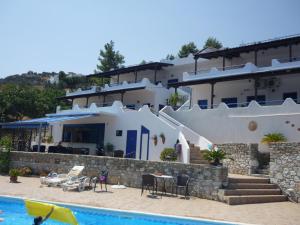 a villa with a swimming pool and a house at Studios Avra in Akhladherí