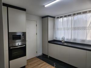 a kitchen with a sink and a microwave at Vista Mar - AC, Parking and pool in Funchal